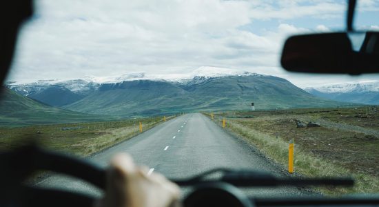 Vue sur une route et une montagne depuis l'habitacle d'une voiture